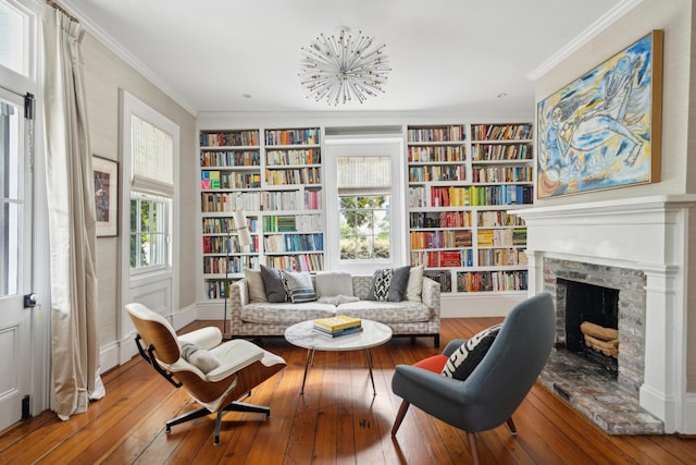 living area with hardwood / wood-style floors, ornamental molding, a wealth of natural light, and built in features