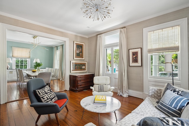 sitting room featuring hardwood / wood-style flooring, ornamental molding, plenty of natural light, and an inviting chandelier