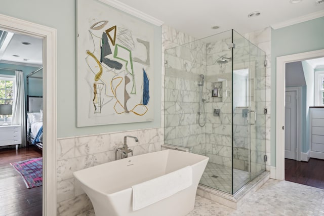 bathroom with sink, crown molding, hardwood / wood-style flooring, tile walls, and plus walk in shower