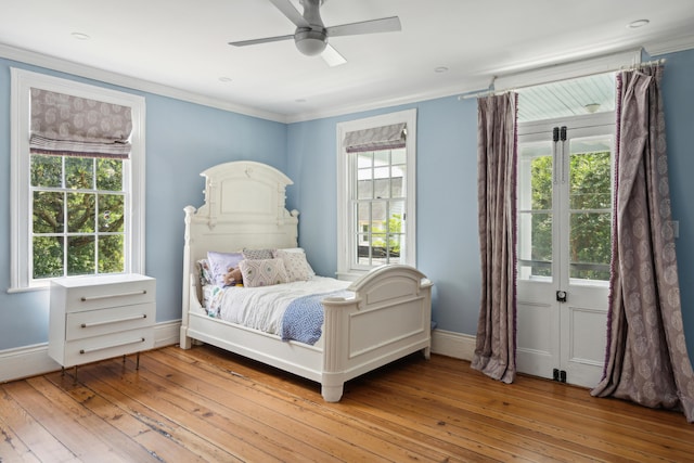 bedroom featuring ceiling fan, ornamental molding, and light wood-type flooring