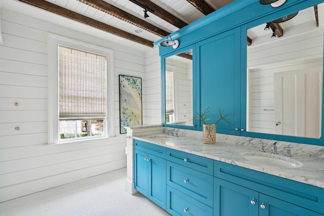 bathroom with beamed ceiling, vanity, and wooden walls