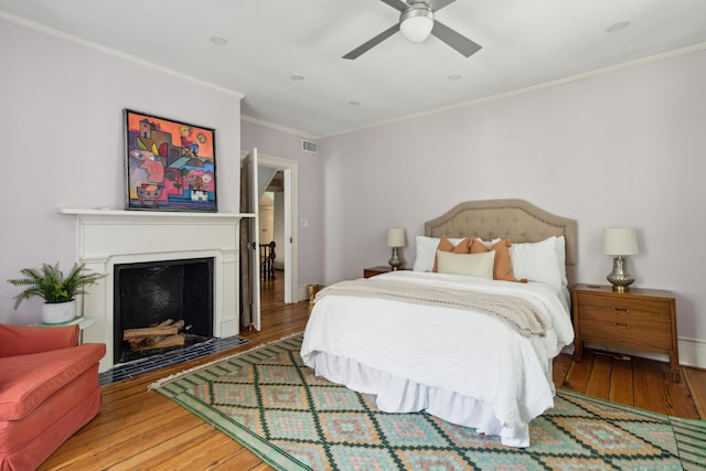 bedroom with ceiling fan, ornamental molding, and wood-type flooring