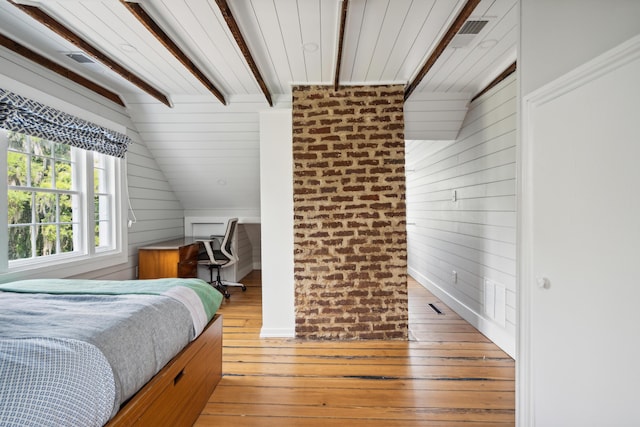 bedroom with vaulted ceiling with beams, light hardwood / wood-style floors, and wood walls