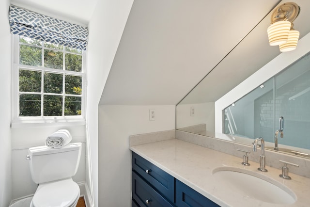 bathroom with lofted ceiling, vanity, toilet, and a shower with shower door