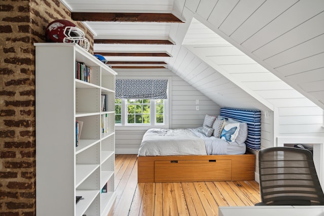 unfurnished bedroom featuring hardwood / wood-style floors, lofted ceiling with beams, and wood walls