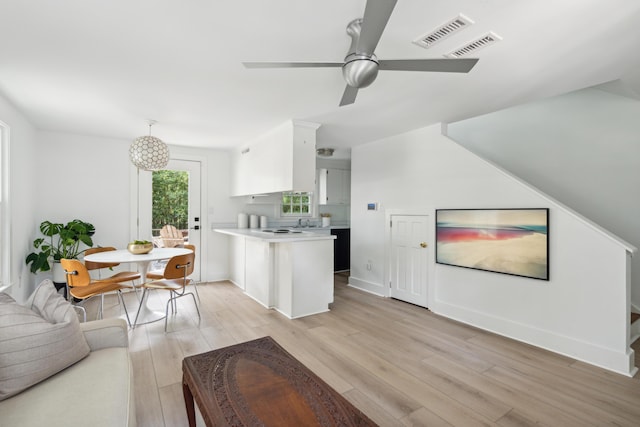 kitchen featuring ceiling fan, pendant lighting, white cabinets, and light wood-type flooring