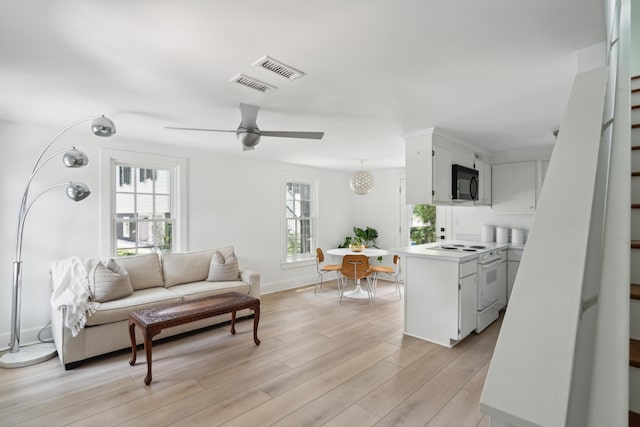 living room with ceiling fan and light hardwood / wood-style flooring