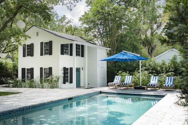 back of house featuring an outbuilding and a patio area