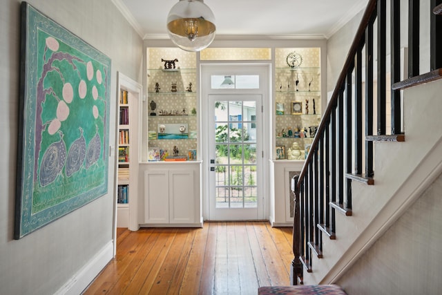 entrance foyer with crown molding and light hardwood / wood-style flooring