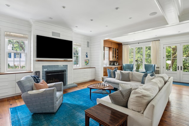 living room with wood-type flooring, wooden walls, and french doors