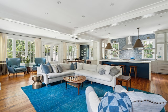 living room featuring beam ceiling, hardwood / wood-style flooring, and plenty of natural light