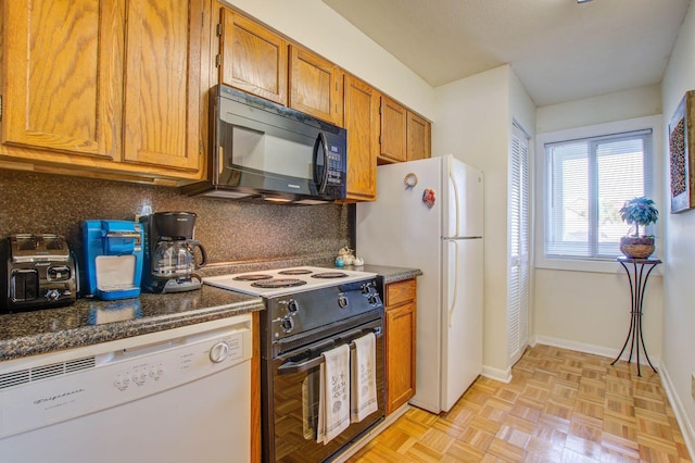 kitchen with white appliances, tasteful backsplash, light parquet floors, and dark stone counters