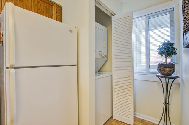 laundry room featuring light parquet flooring and stacked washer and clothes dryer