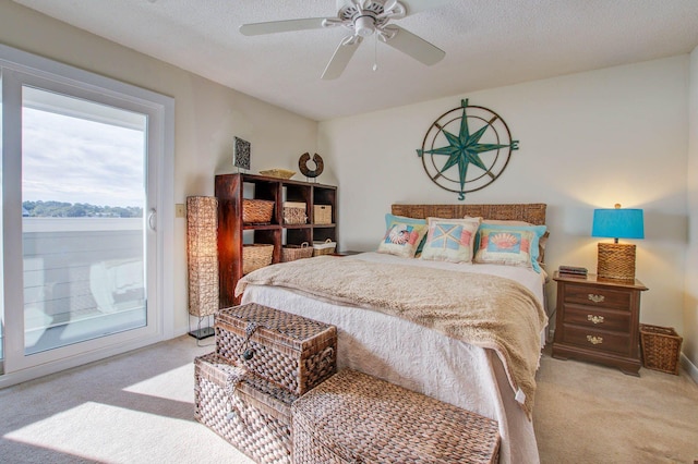 bedroom featuring ceiling fan, light carpet, and a textured ceiling