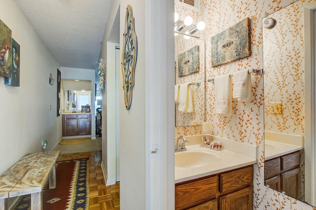 bathroom featuring vanity, a textured ceiling, and parquet flooring