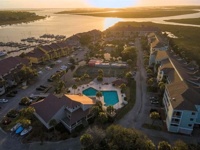 aerial view at dusk featuring a water view