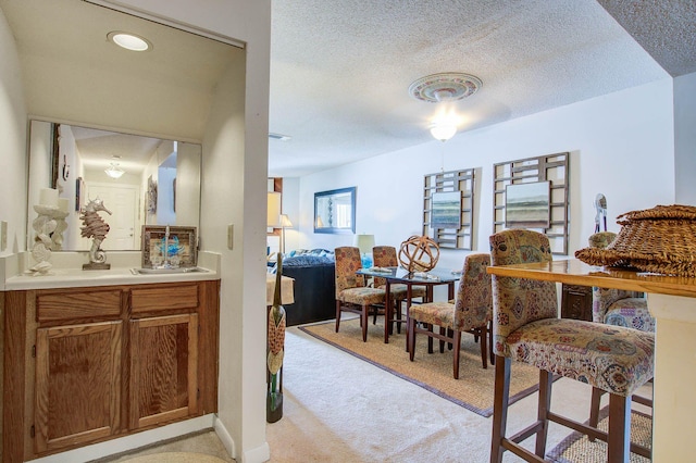 carpeted dining room with a textured ceiling