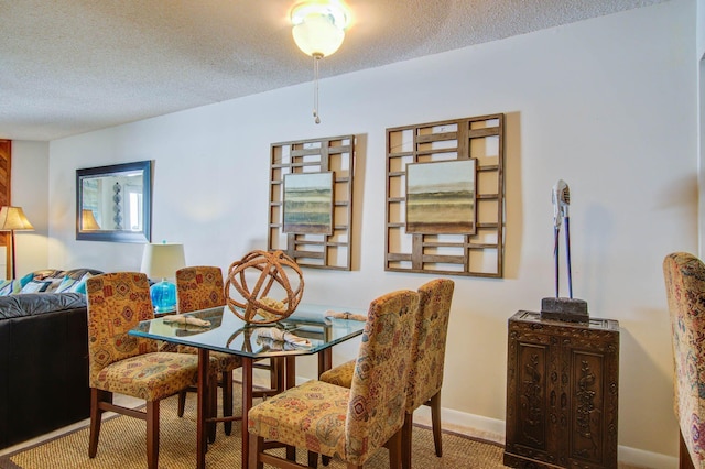 carpeted dining area featuring a textured ceiling