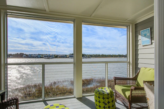 sunroom featuring a water view and a healthy amount of sunlight