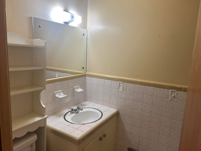 bathroom with vanity, toilet, and tile walls