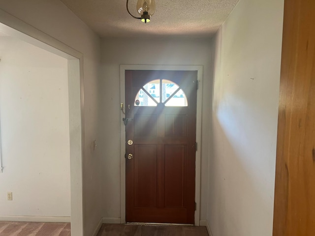 doorway to outside with a textured ceiling