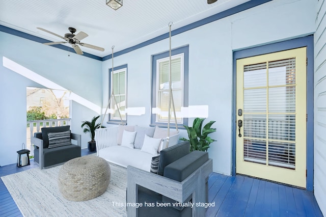 view of patio featuring ceiling fan, a wooden deck, and an outdoor living space