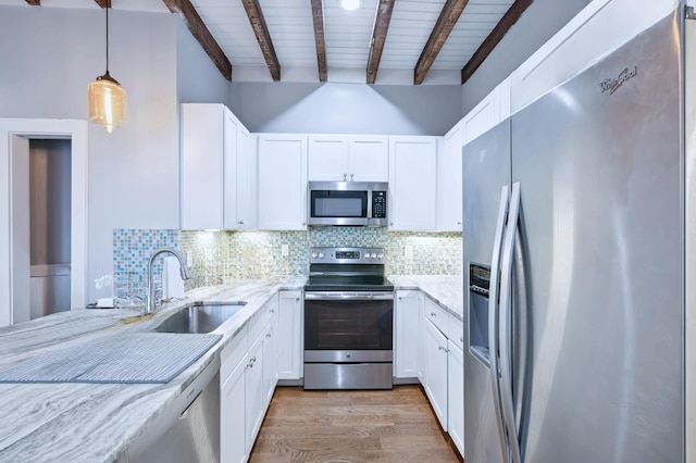 kitchen featuring decorative light fixtures, beam ceiling, sink, white cabinetry, and appliances with stainless steel finishes