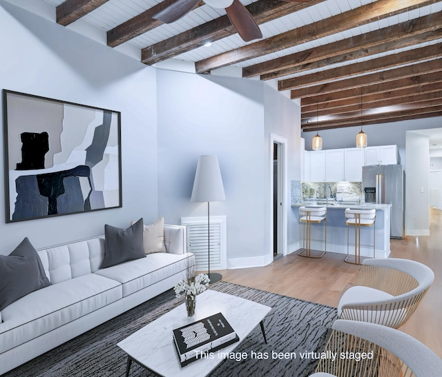 living room with light hardwood / wood-style floors, ceiling fan, wooden ceiling, beam ceiling, and sink