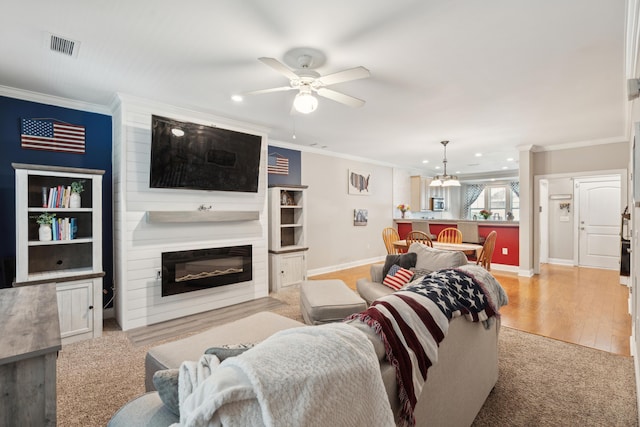 5511 Colonial Chatsworth Cir N, Charleston, SC 29418 - living room featuring crown molding, a ceiling fan, recessed lighting, a large fireplace, and a chandelier