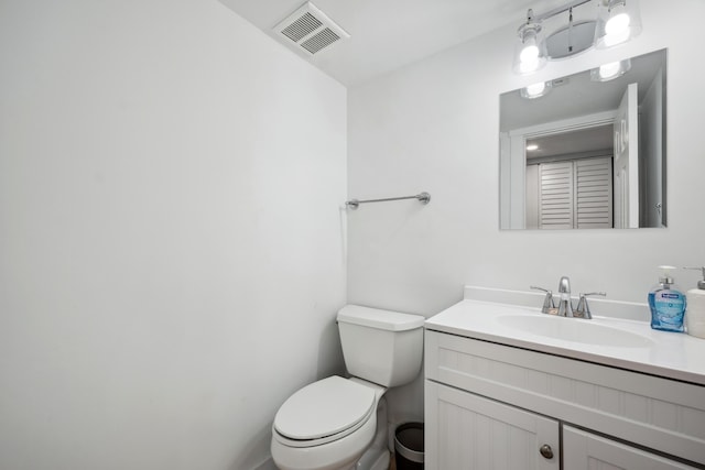 half bath featuring toilet, visible vents, and vanity