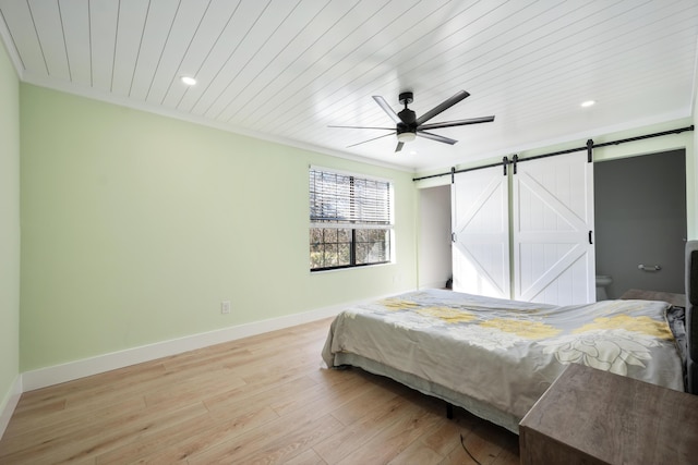 bedroom with a barn door, light wood-style flooring, recessed lighting, wood ceiling, and baseboards