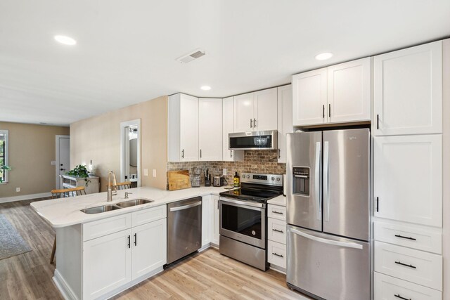 1166 Julian Clark Rd, Charleston, SC 29412 - kitchen featuring stainless steel appliances, a sink, light wood-style flooring, light countertops, and white cabinets