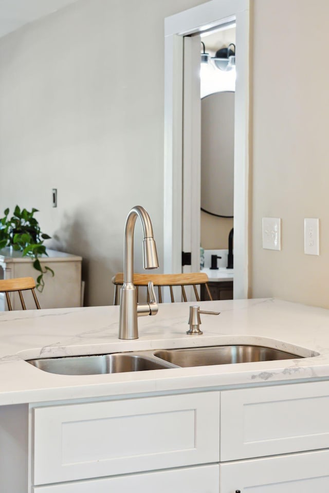 1166 Julian Clark Rd, Charleston, SC 29412 - kitchen featuring white cabinetry, a sink, and light stone counters