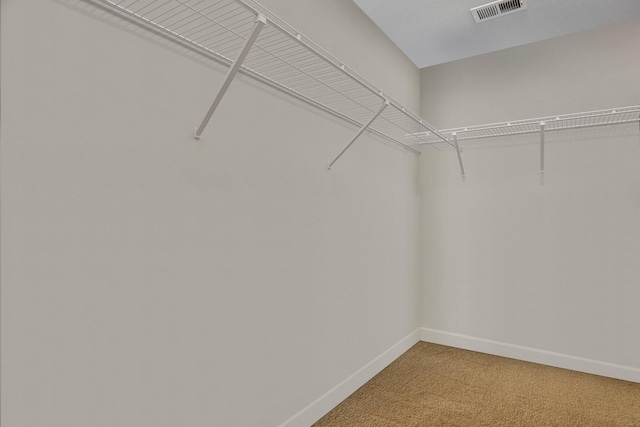 walk in closet featuring light colored carpet and visible vents