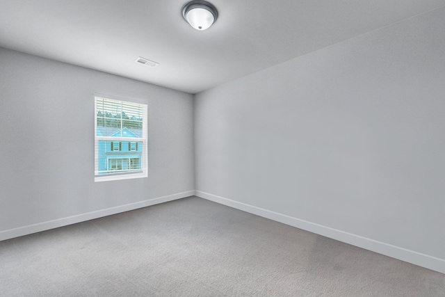 carpeted empty room featuring visible vents and baseboards