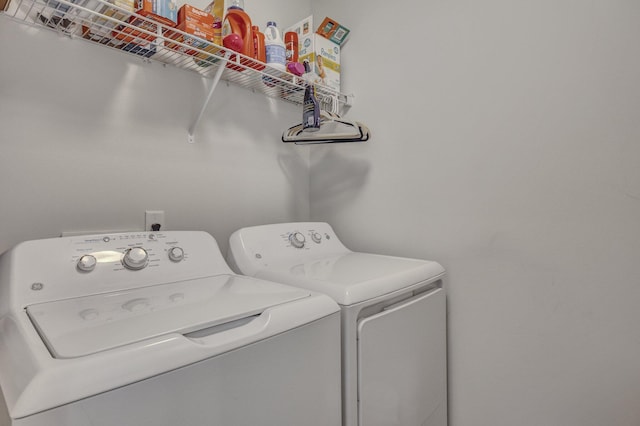 clothes washing area featuring laundry area and washer and clothes dryer