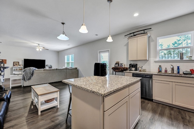 kitchen with light stone counters, dark wood finished floors, a sink, black dishwasher, and tasteful backsplash