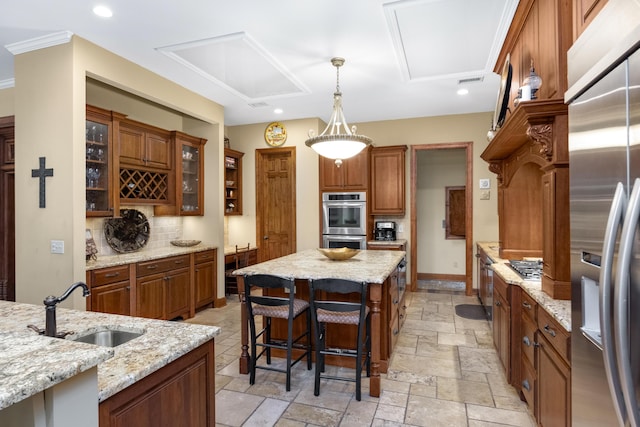 kitchen with stone tile floors, stainless steel appliances, a kitchen island, brown cabinets, and glass insert cabinets