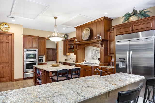 kitchen featuring a warming drawer, a breakfast bar area, open shelves, appliances with stainless steel finishes, and a kitchen island with sink