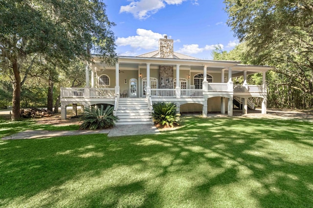 view of front facade featuring covered porch, stairs, and a front lawn