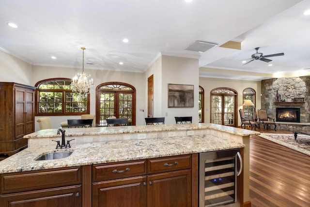 kitchen featuring beverage cooler, open floor plan, a sink, and a wealth of natural light