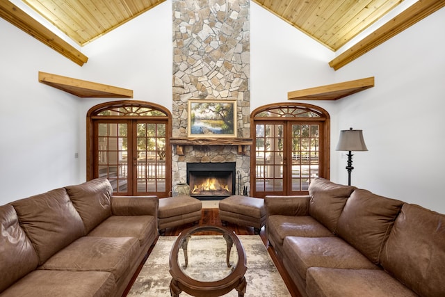 living room featuring french doors, wooden ceiling, vaulted ceiling, and a stone fireplace