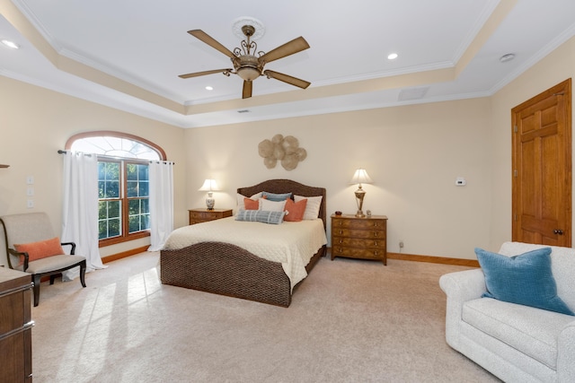 bedroom with crown molding, a tray ceiling, and light colored carpet