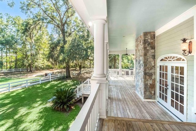 wooden terrace with french doors, fence, and a lawn