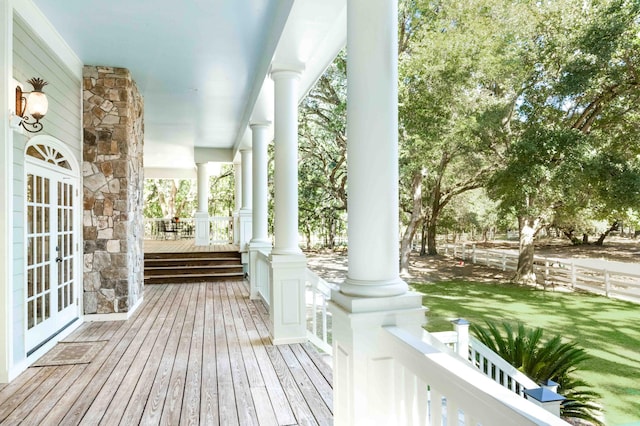 deck featuring covered porch and a lawn