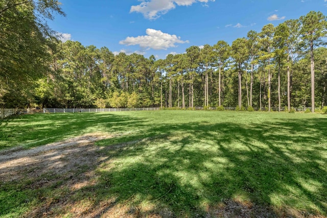 view of yard featuring fence and a forest view