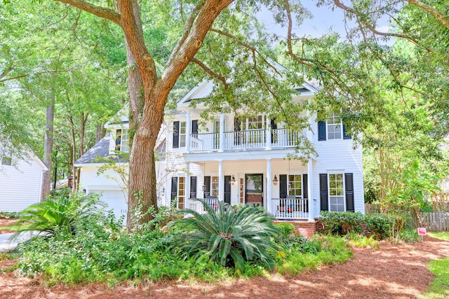 view of front facade with a porch, a balcony, and an attached garage