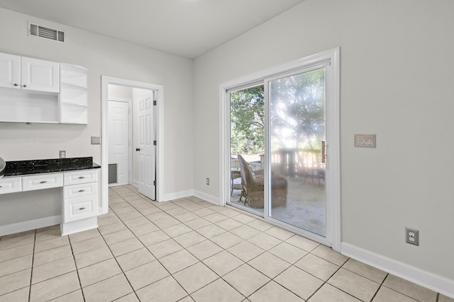 kitchen with visible vents, baseboards, built in desk, white cabinetry, and open shelves