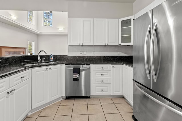 kitchen featuring light tile patterned floors, tasteful backsplash, appliances with stainless steel finishes, and a sink