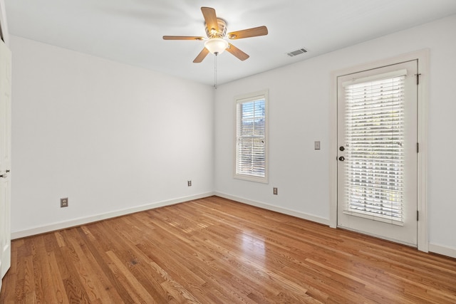 empty room featuring visible vents, baseboards, light wood-type flooring, and a ceiling fan